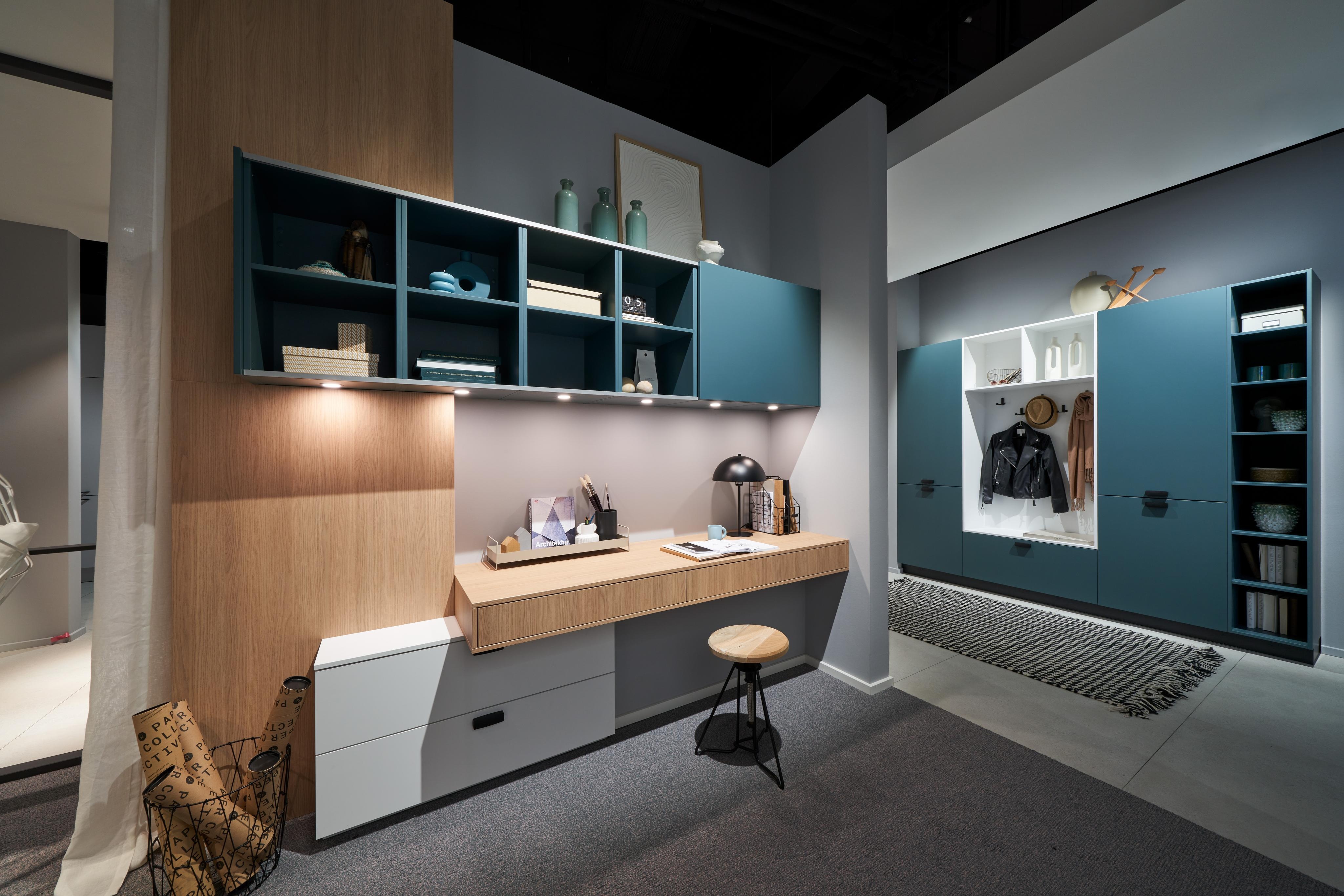 Türkise Schränke und Regale mit einem Arbeitsplatztresen in Holz.