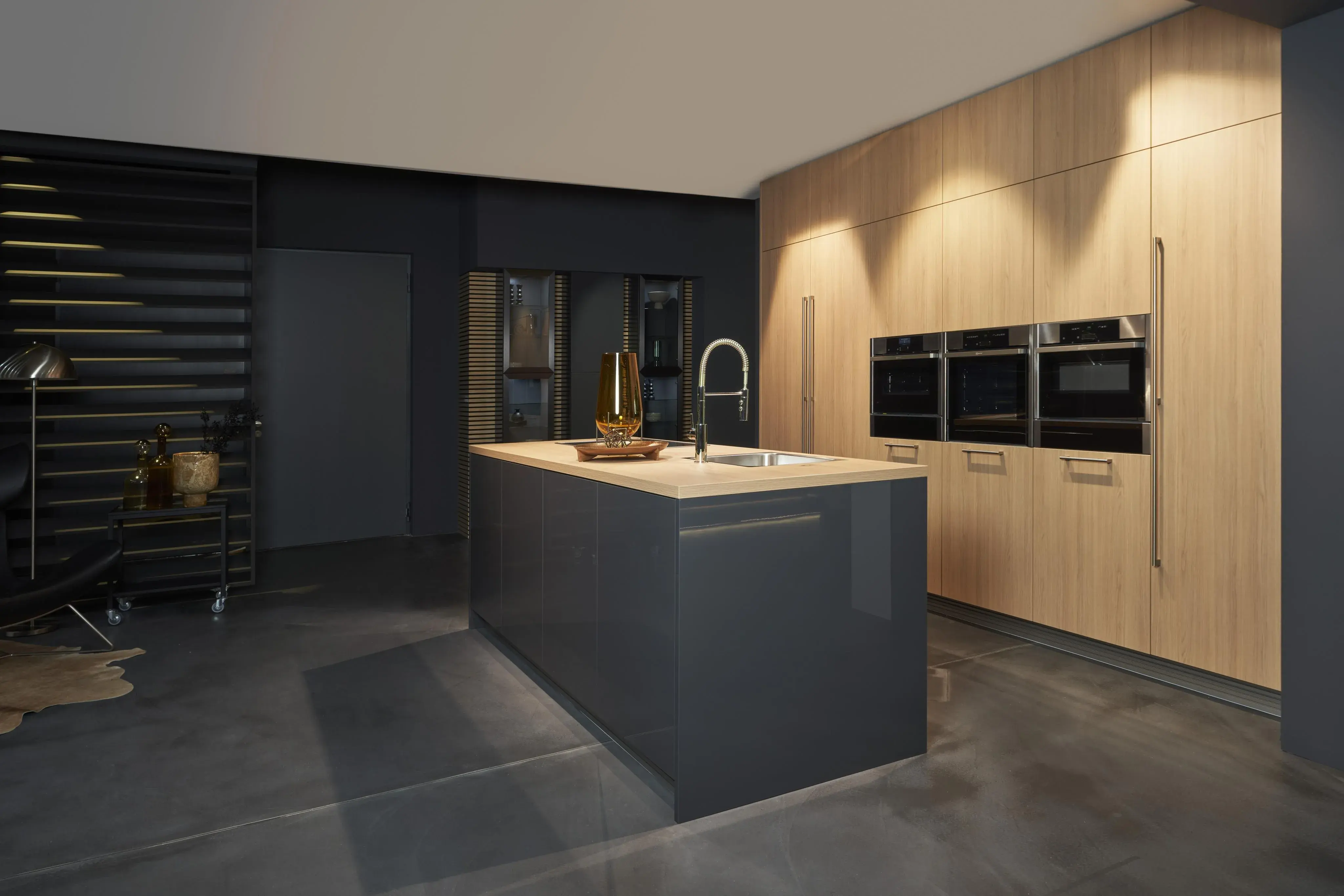 Küche von Häcker in Graphit mit Kücheninsel und Hochschränken in Feineiche abgesetzt
